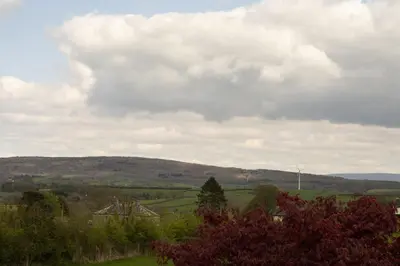 a view of a green field with a cloudy sky at Manor Farm Barn Cottage in Burton