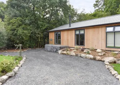 a house with a gravel driveway in front of it at Blenkett Wood Lodge Park in Kents Bank