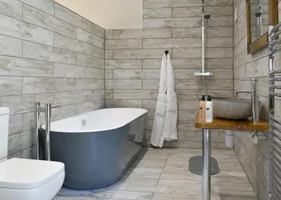a bathroom with a tub and a toilet and a sink at Blenkett Wood Lodge Park in Kents Bank