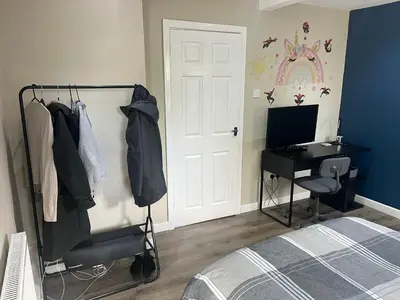 a bedroom with a bed and a desk with a computer at Spacious 2 Bed Ribble Valley Apartments in Blackburn