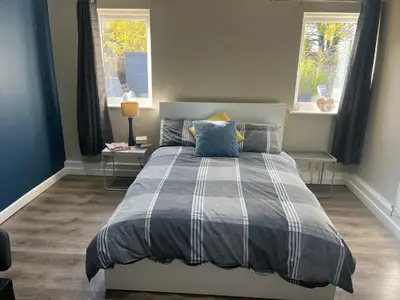 a bedroom with a bed and two windows at Spacious 2 Bed Ribble Valley Apartments in Blackburn