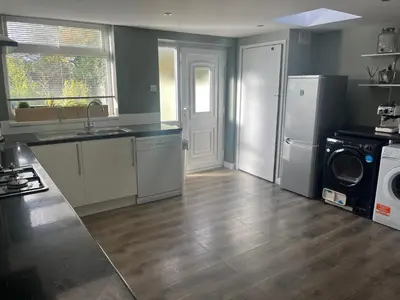 a kitchen with a refrigerator and a washer and dryer at Spacious 2 Bed Ribble Valley Apartments in Blackburn