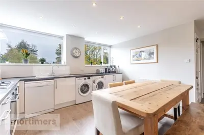 a kitchen with a wooden table and a dining room at Spacious 2 Bed Ribble Valley Apartments in Blackburn