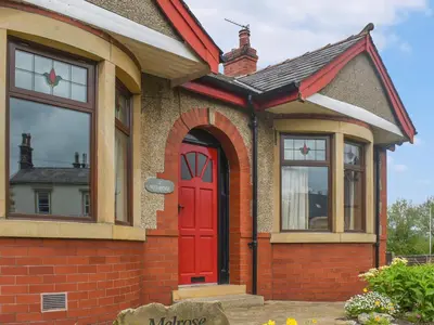 a house with a red door and windows at Melrose in Clitheroe