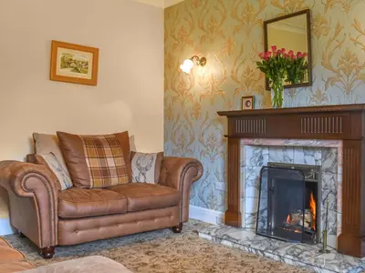 a living room with a couch and a fireplace at Melrose in Clitheroe