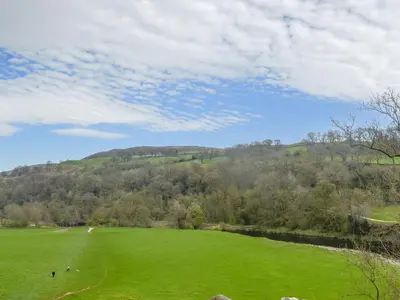 a large green field with a hill in the background at Melrose in Clitheroe