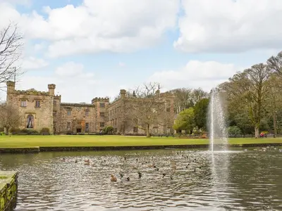 a pond in front of a castle with ducks in it at Melrose in Clitheroe
