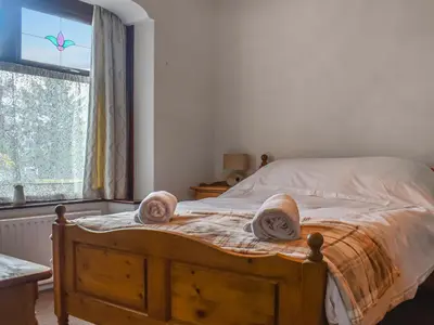 a bedroom with a wooden bed with towels on it at Melrose in Clitheroe