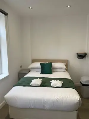 a bedroom with a large bed with towels on it at Araan House Hotel -Families and Couples Only in Blackpool