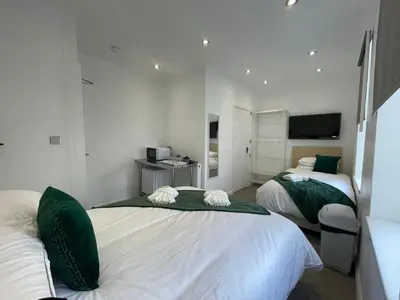 a bedroom with two beds with green and white at Araan House Hotel -Families and Couples Only in Blackpool