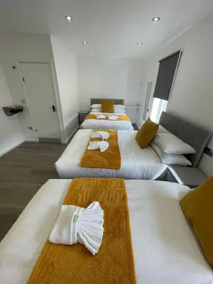 a group of four beds in a room at Araan House Hotel -Families and Couples Only in Blackpool