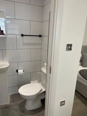 a white bathroom with a toilet and a sink at Araan House Hotel -Families and Couples Only in Blackpool