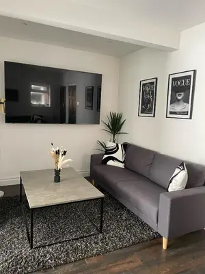 a living room with a couch and a table at Lovely 2 Bed Full House By The Beach in Liverpool