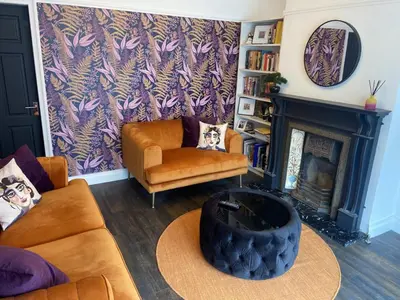 a living room with a couch and a fireplace at Lovely 2 Bed Full House By The Beach in Liverpool