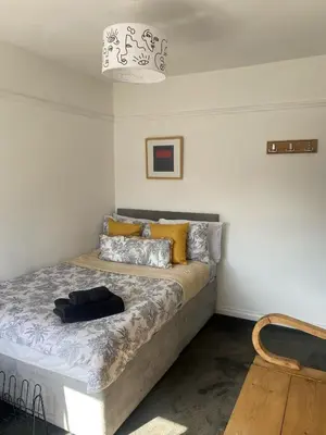 a bedroom with a bed with yellow pillows at Lovely 2 Bed Full House By The Beach in Liverpool