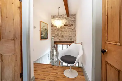 a white chair sitting in the middle of a hallway at The Riverside Tailor's Retreat at Wray in Wray