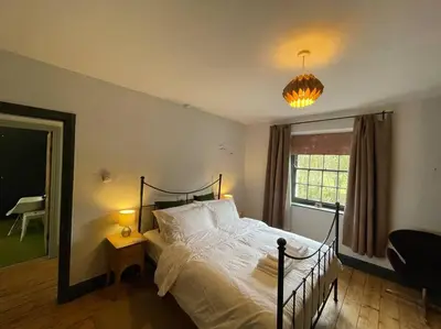a bedroom with a bed and a window and a lamp at The Riverside Tailor's Retreat at Wray in Wray