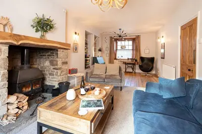 a living room with a couch and a fireplace at The Riverside Tailor's Retreat at Wray in Wray