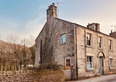 an old stone house with a brick wall at The Riverside Tailor's Retreat at Wray in Wray