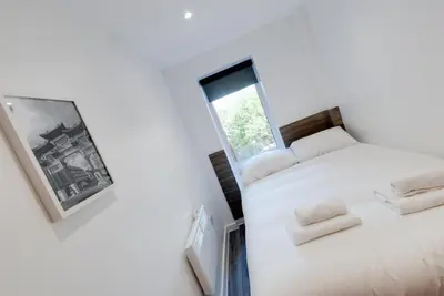 a bedroom with a white bed and a window at Liverpool Short Stay Apartments in Liverpool