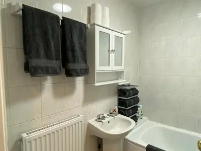 a bathroom with a sink and a toilet and towels at Well-appointed apartment in New Brighton in New Brighton