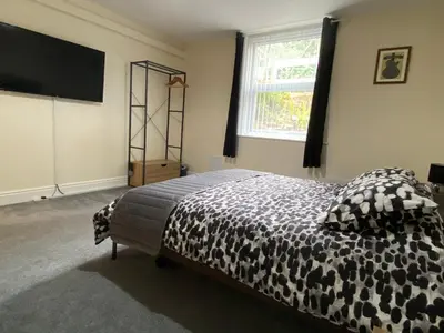 a bedroom with a bed and a flat screen tv at Well-appointed apartment in New Brighton in New Brighton