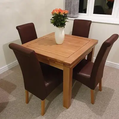 a wooden table with chairs and a vase with flowers on it at ChurstonBnB, private flat within family home, Bolton in Lostock