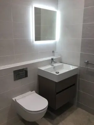a bathroom with a toilet and a sink and a mirror at ChurstonBnB, private flat within family home, Bolton in Lostock