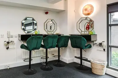 a barber shop with green chairs and mirrors at VIP city centre apartment with secure free parking in Liverpool
