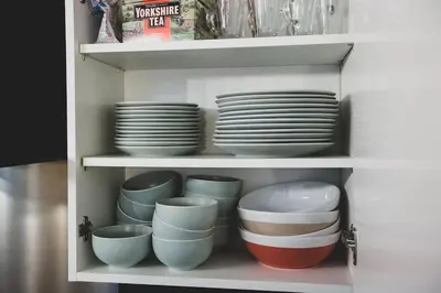 a cupboard filled with plates and bowls and dishes at VIP city centre apartment with secure free parking in Liverpool
